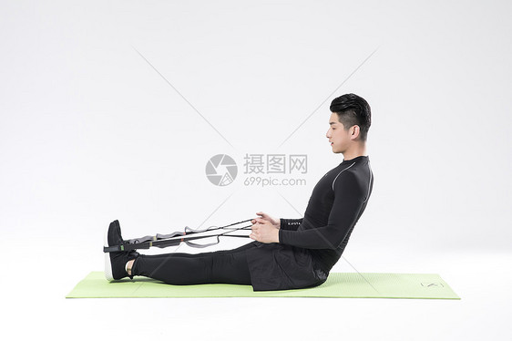 用瑜伽绳拉升的运动男性图片