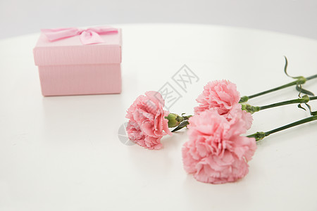桌子上的康乃馨与礼盒图片