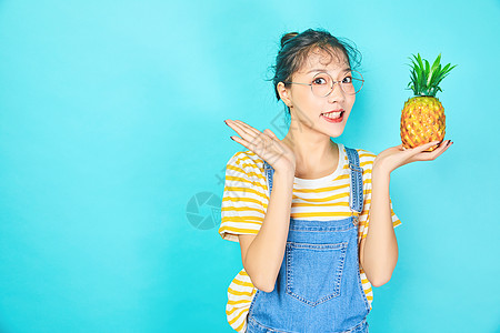 年轻女性色彩搭配拿着水果背景图片