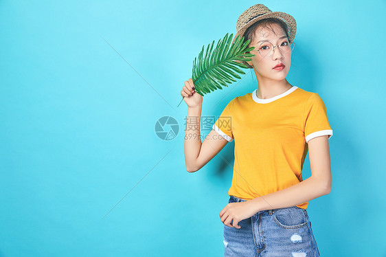 年轻活力女性手持棕榈叶图片