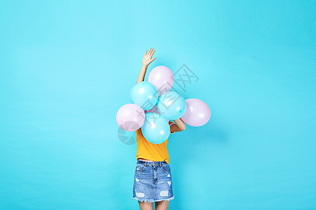 青年活力女性手持彩色气球背景图片