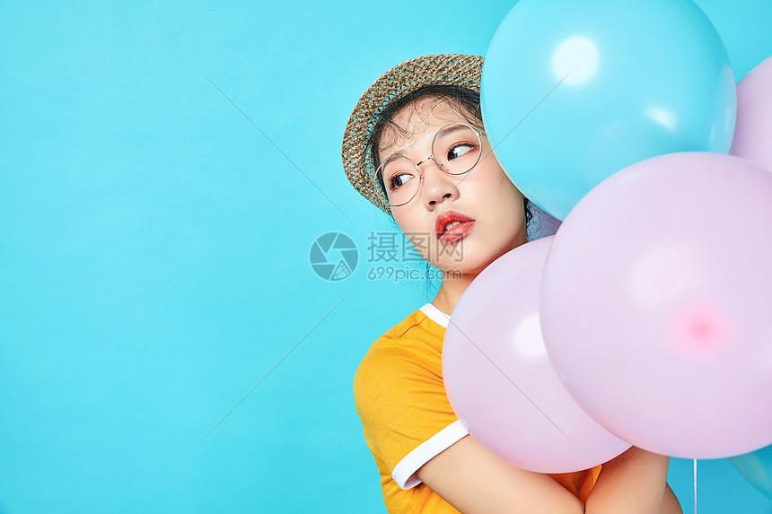 青年活力女性手持彩色气球图片