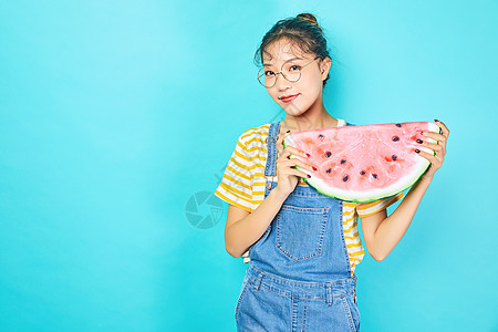 年轻女性手拿水果西瓜背景图片