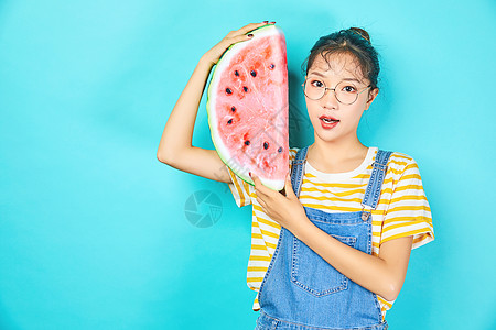 年轻女性手拿水果西瓜背景图片