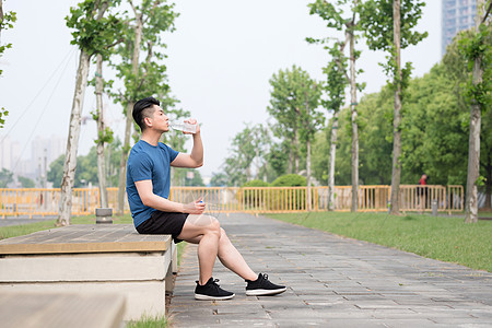 运动后坐着休息喝水放松的年轻男性图片