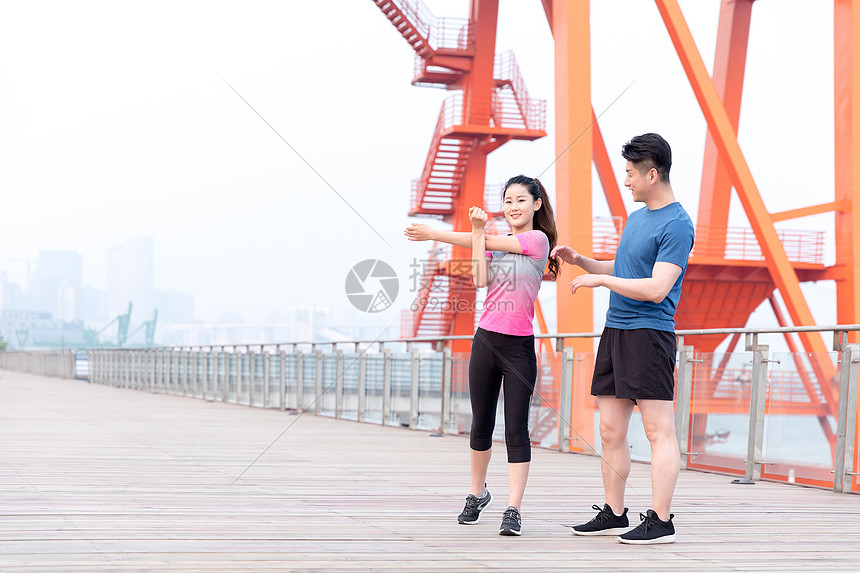 教练指导年轻女子热身运动户外锻炼图片