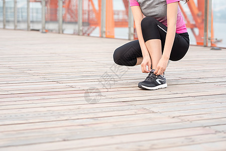 户外运动女性蹲下系鞋带图片