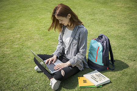 女同学在草坪用电脑学习图片