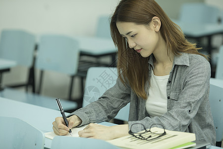 研究女学生在大学教室里学习背景