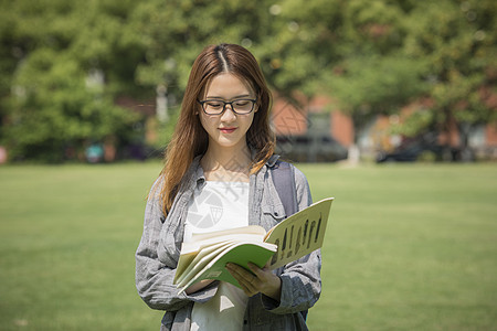 女学生在操场上看书同学高清图片素材