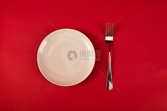 红色背景上的叉子与盘子图片