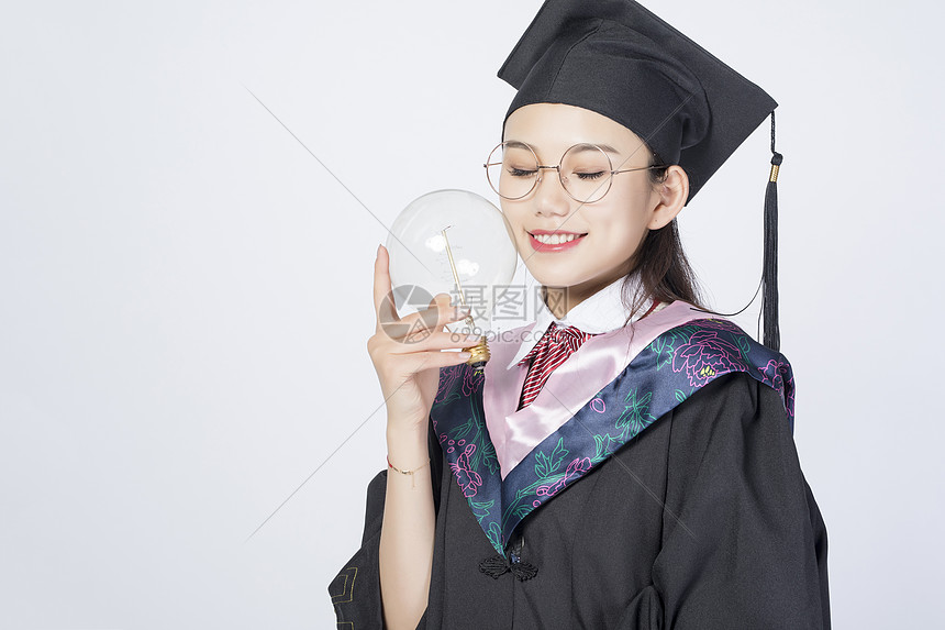 拿着灯泡的毕业女学生图片