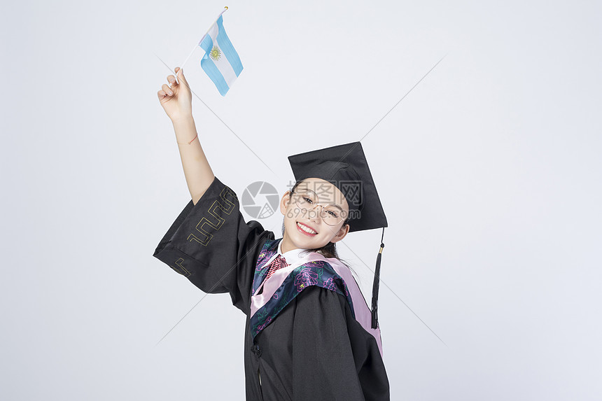 拿着国旗的毕业女学生图片