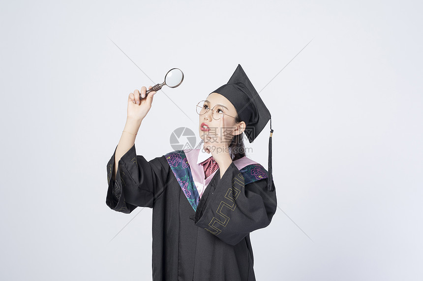 拿着放大镜的毕业女学生图片