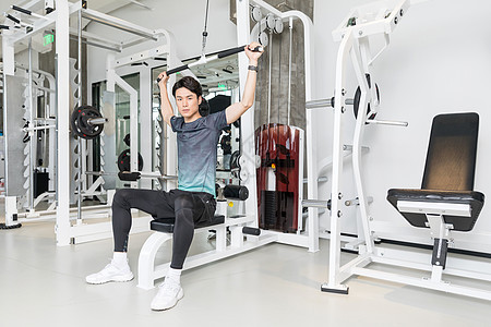 男子健身房使用健身器械运动图片