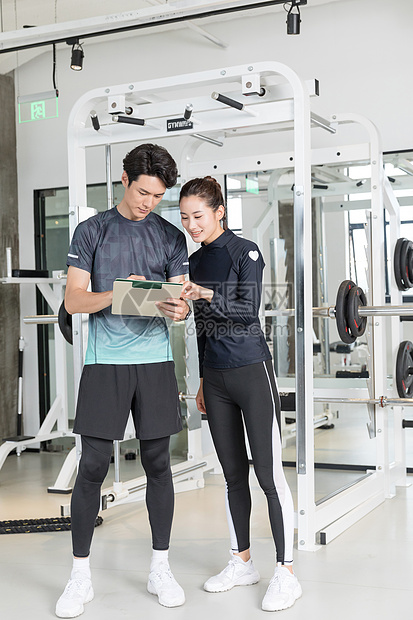 健身教练和年轻女学员健身房合影