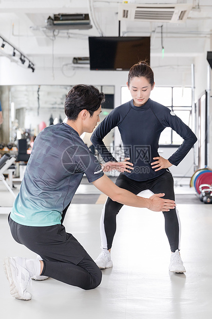 年轻女子在教练指导下健身运动图片