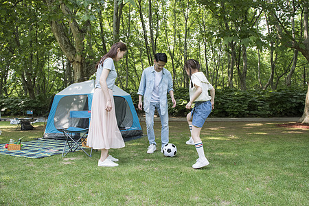 女儿父母家庭亲子户外露营踢足球背景