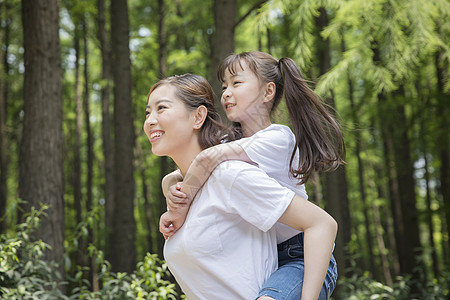 妈妈背着女儿在公园走路图片