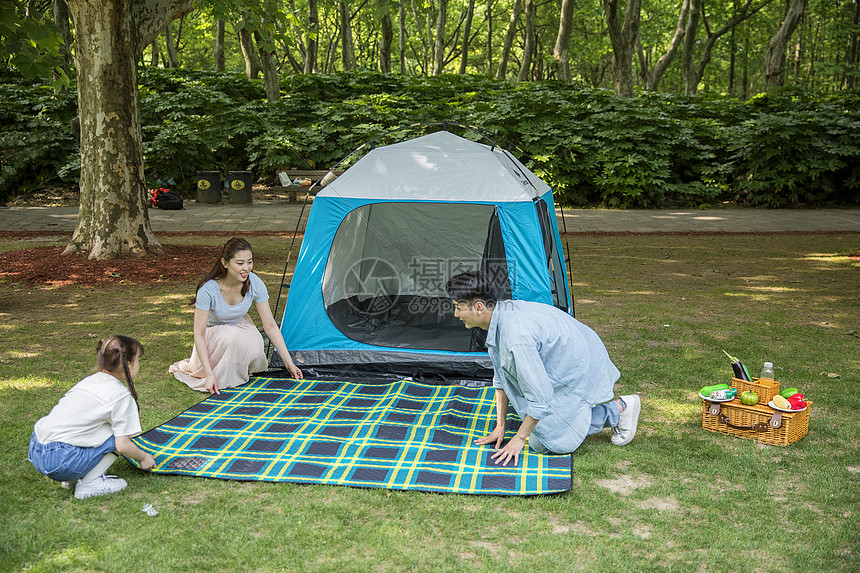 一家人在露营时铺野餐垫