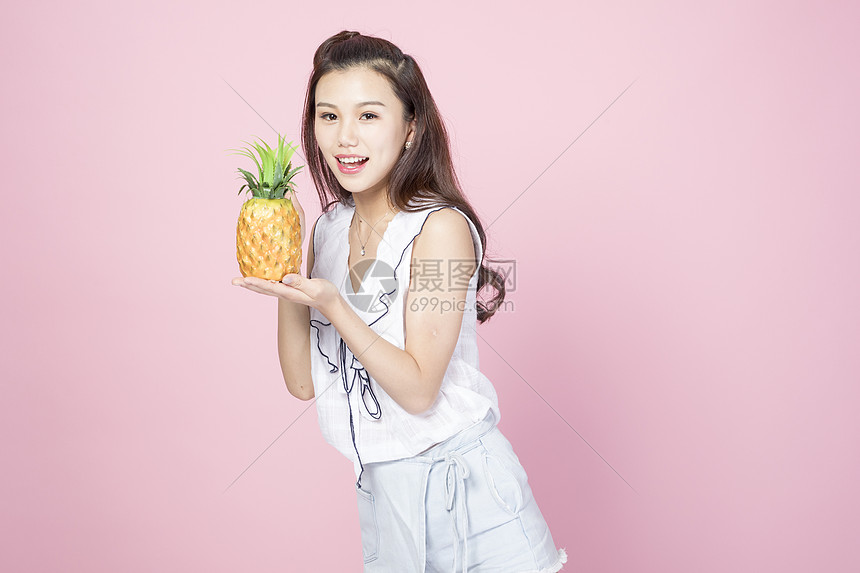 拿着菠萝的青年女性图片