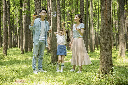 一家人野营六一儿童节一家人在森林公园吹泡泡背景