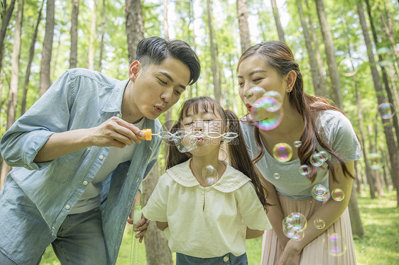 一家人在森林公园吹泡泡图片
