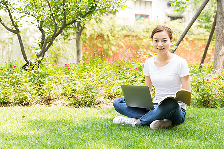 青春大学生在草地上学习图片