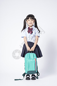 拉着行李去上学背着书包的小女孩背景