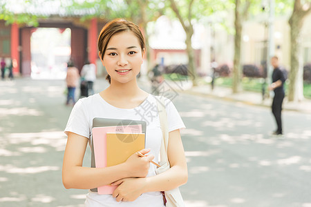 本笔青春大学生抱着书本背景