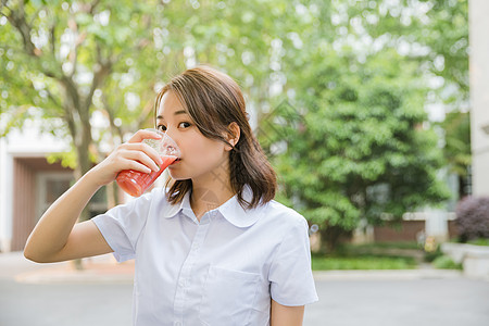 校园写真青春女孩喝饮料背景图片