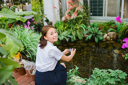 校园写真青春女生花园内拍照图片