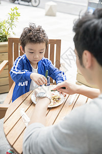 带着孩子吃东西的父亲高清图片