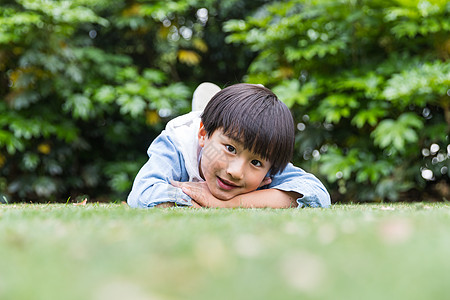 可爱儿童开心趴在草地上图片