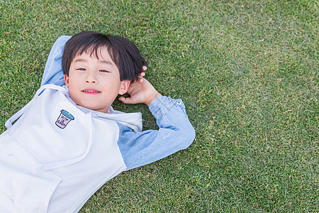 在公园休息可爱儿童开心躺在草地上背景