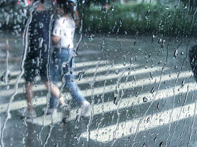 玻璃雨滴雨中漫步的情侣背景