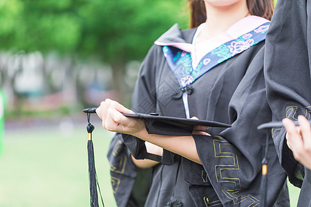 毕业季大学生手拿学士帽特写图片