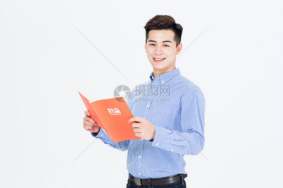 手拿笔记本阅读的青年男性图片