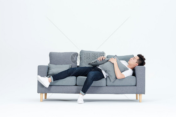 躺在沙发上休息睡觉的青年男性图片