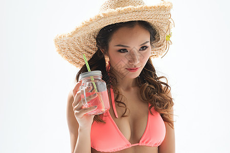 穿粉色比基尼的美女头戴遮阳帽喝饮料背景图片