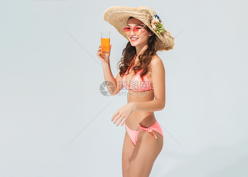 穿粉色比基尼的美女头戴遮阳帽喝饮料图片