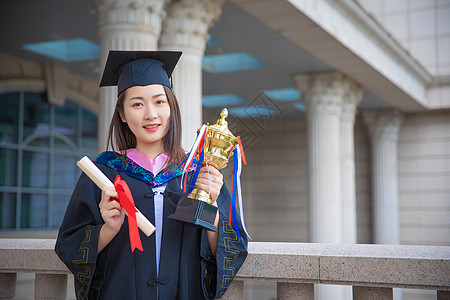 大学毕业奖杯优秀毕业生双手拿着证书和奖杯背景