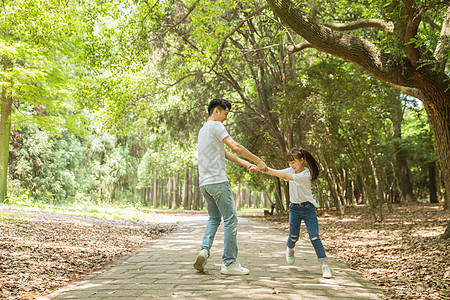 父亲节公园里父亲牵孩子转圈背景