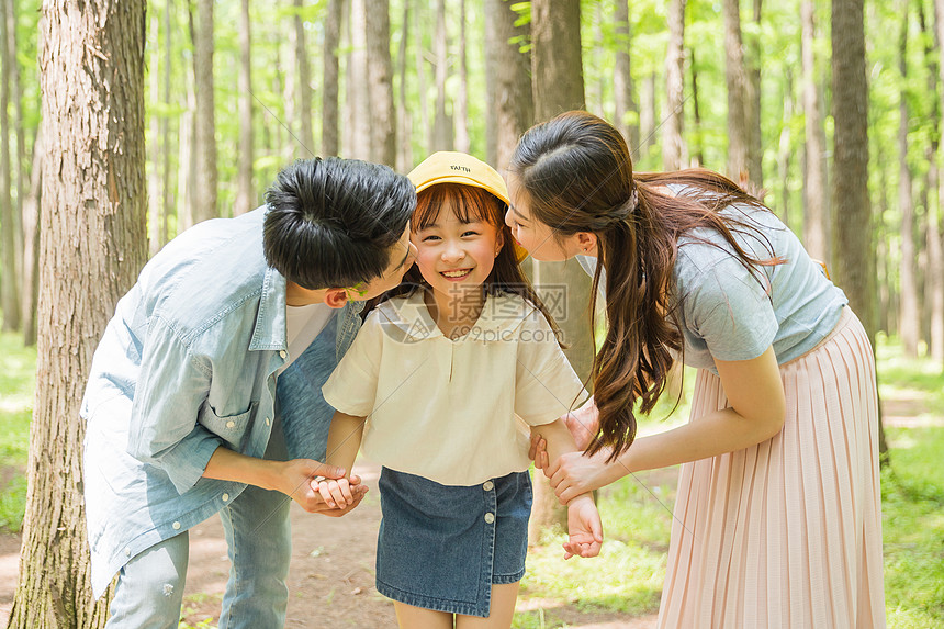 公园森林里父母亲吻孩子图片