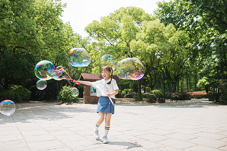 公园里可爱女孩玩吹泡泡图片