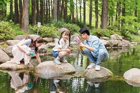 公园锻炼一家人小河上玩水枪背景