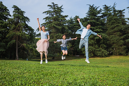 孩子跳跃一家人草地上跳跃背景