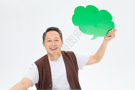 手拿绿色气泡框的老年人图片