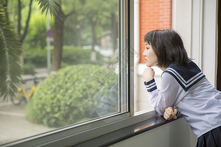 女学生眺望教室窗外高清图片