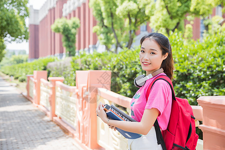 耳机模特大学生抱着书本背景